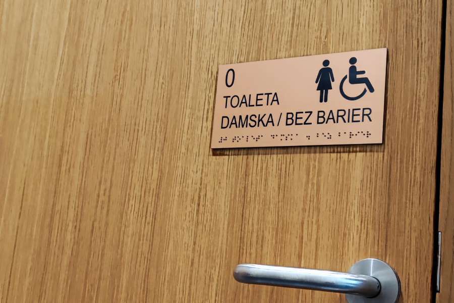 Oznakowanie budynków - tabliczka informacyjna dla niepełnosprawnych, toaleta bez barier, piktogram i pismo Braille'a