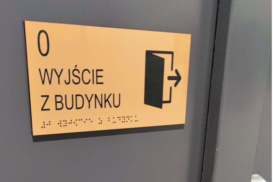 Oznakowanie budynków - tabliczki informacyjne dla osób niepełnosprawnych, wyjście z budynku, piktogram i pismo Braille'a